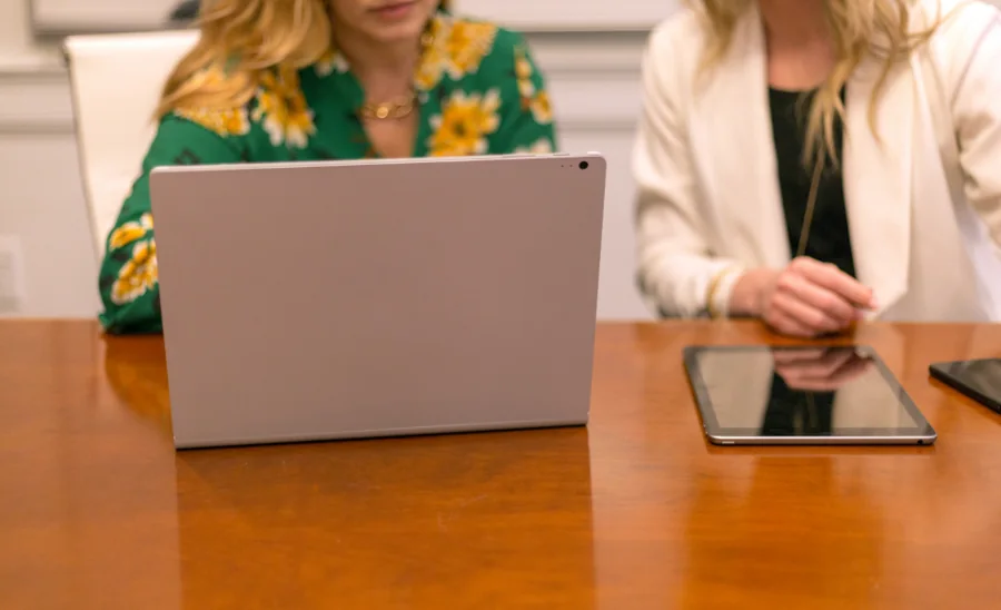 Two people planning an event at a table with a laptop and a tablet